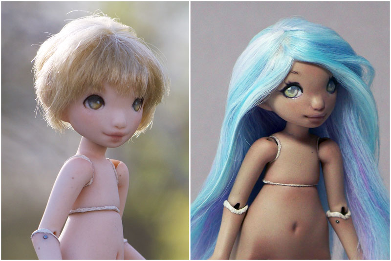 two green eyed dolls one with soft blue hair and tan skin and another with yellow blonde hair