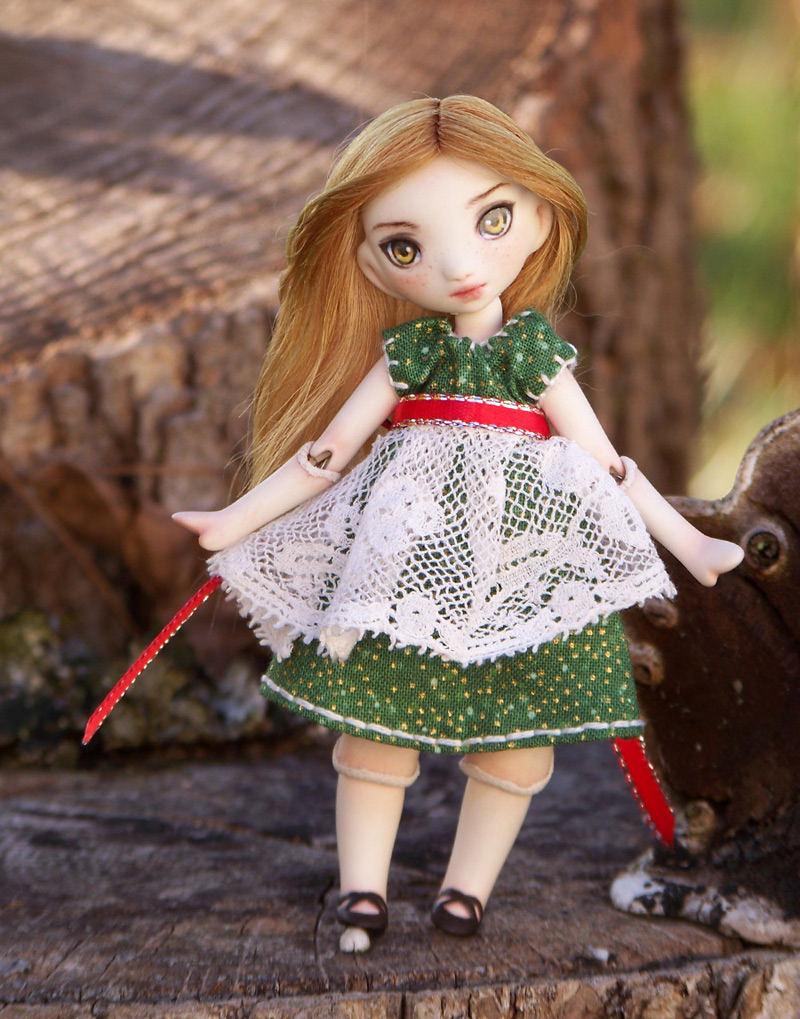 porcelain bjd in a green dress with lace apron