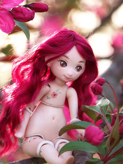 Meka by meow with tiny poppies painted on her body and wine red hair posed with crab-apple blossoms.