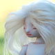 simple porcelain doll with platinum blonde hair and a sleeping expression. 